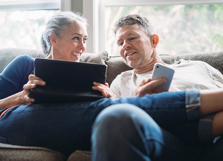 Par kigger på en tablet i sofaen
