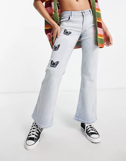 Reclaimed Vintage inspired low rise flare in bleach wash with butterfly embroidery